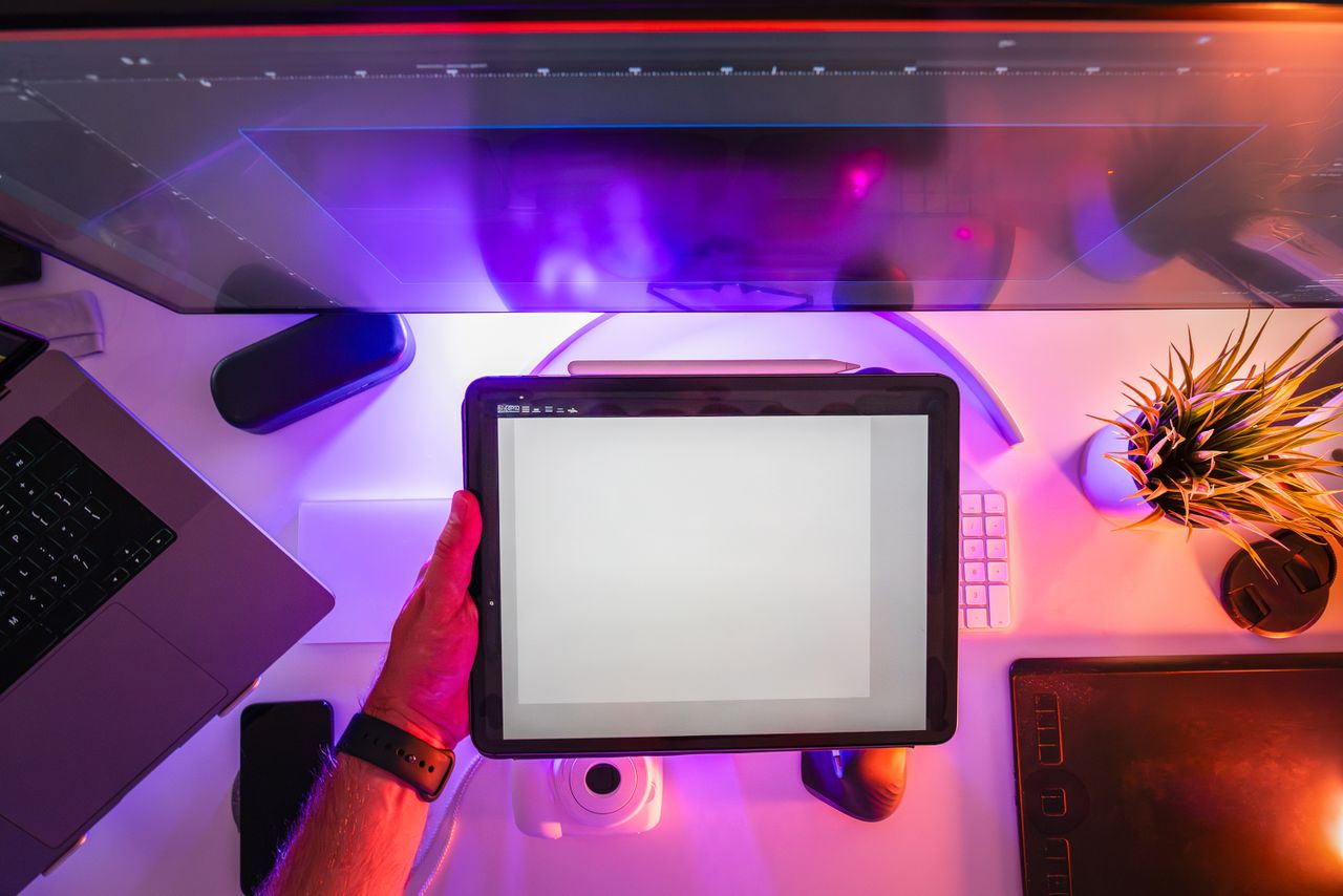 services-03 A vibrant workspace featuring a digital tablet and neon lighting, ideal for designers or photographers.